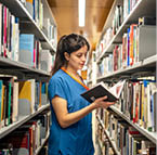 female intern doing research in the library to study