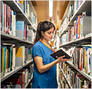 female intern doing research in the library to study