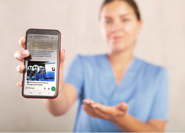 Young female medic in uniform posing in studio with mobile phone in her hands
